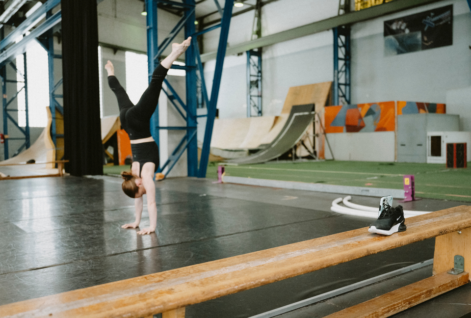 Acrobat training handstands at a circus studio