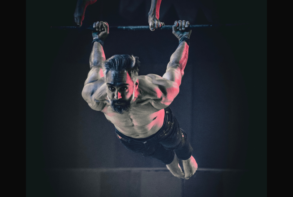 Male trapeze artist performing a back leaver - grip supported by AcroGrip liquid chalk