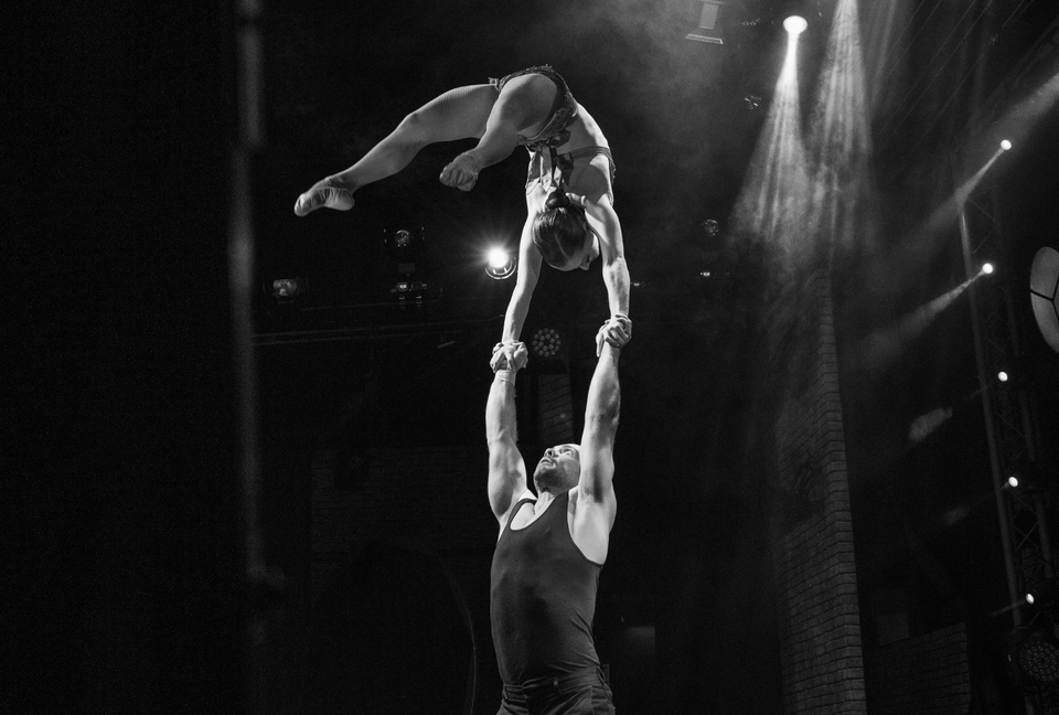Hand to hand circus duo performing on stage -  flexible hand to hand grip