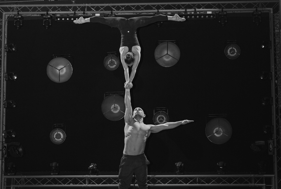 Circus duo training on stage before show - One arm handstand supported by AcroGrip liquid chalk