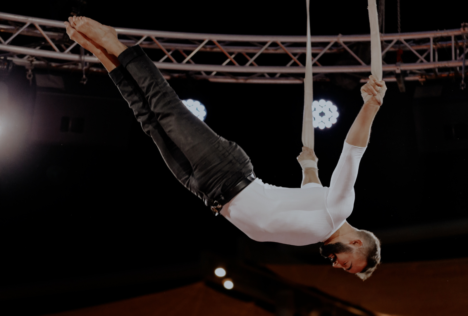 Male straps artist performing on stage - hand grip on straps