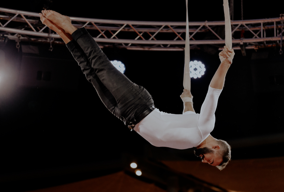 Male straps artist performing on stage - hand grip on straps